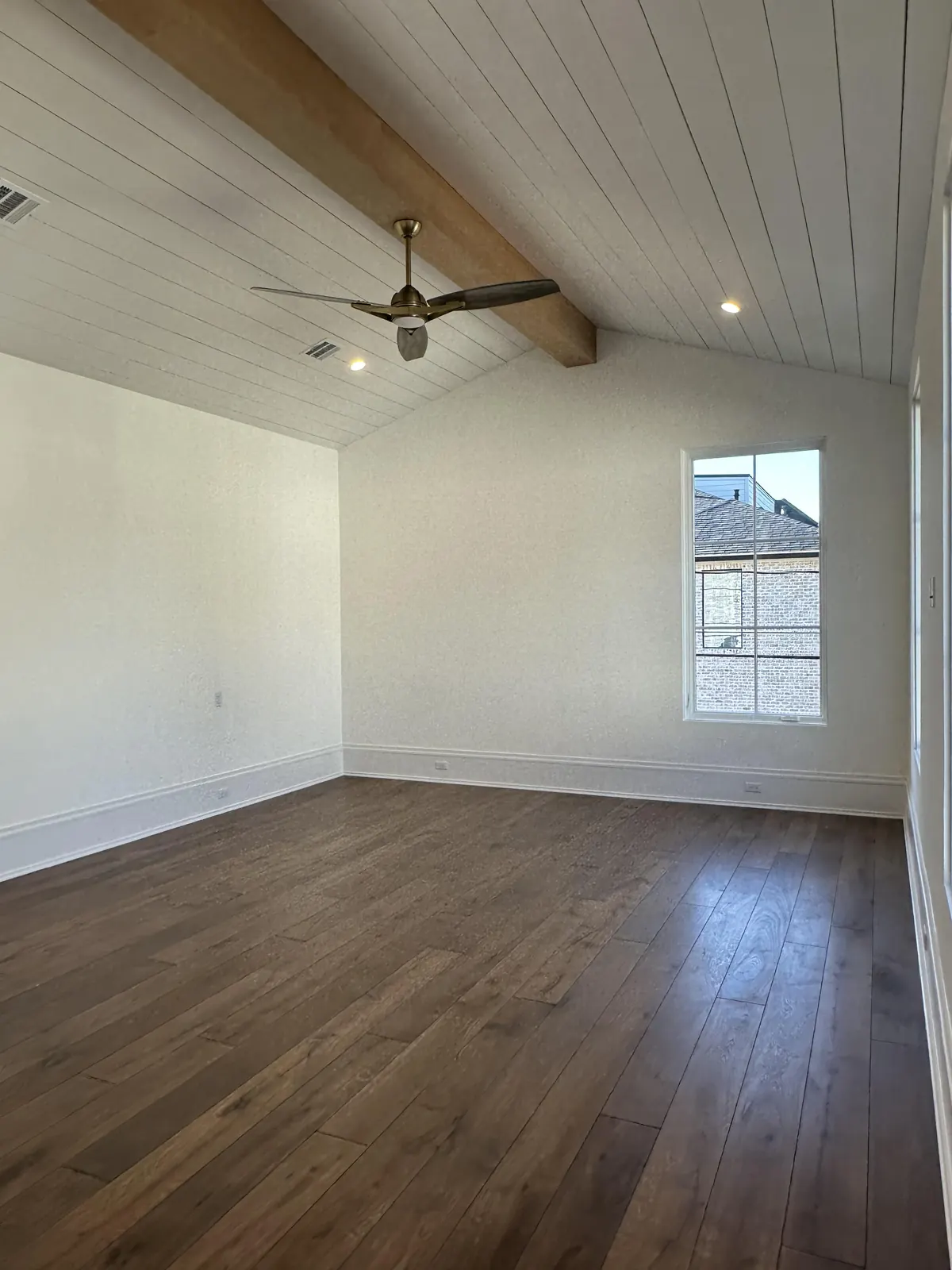 Bright room with a white shiplap ceiling and wood floors