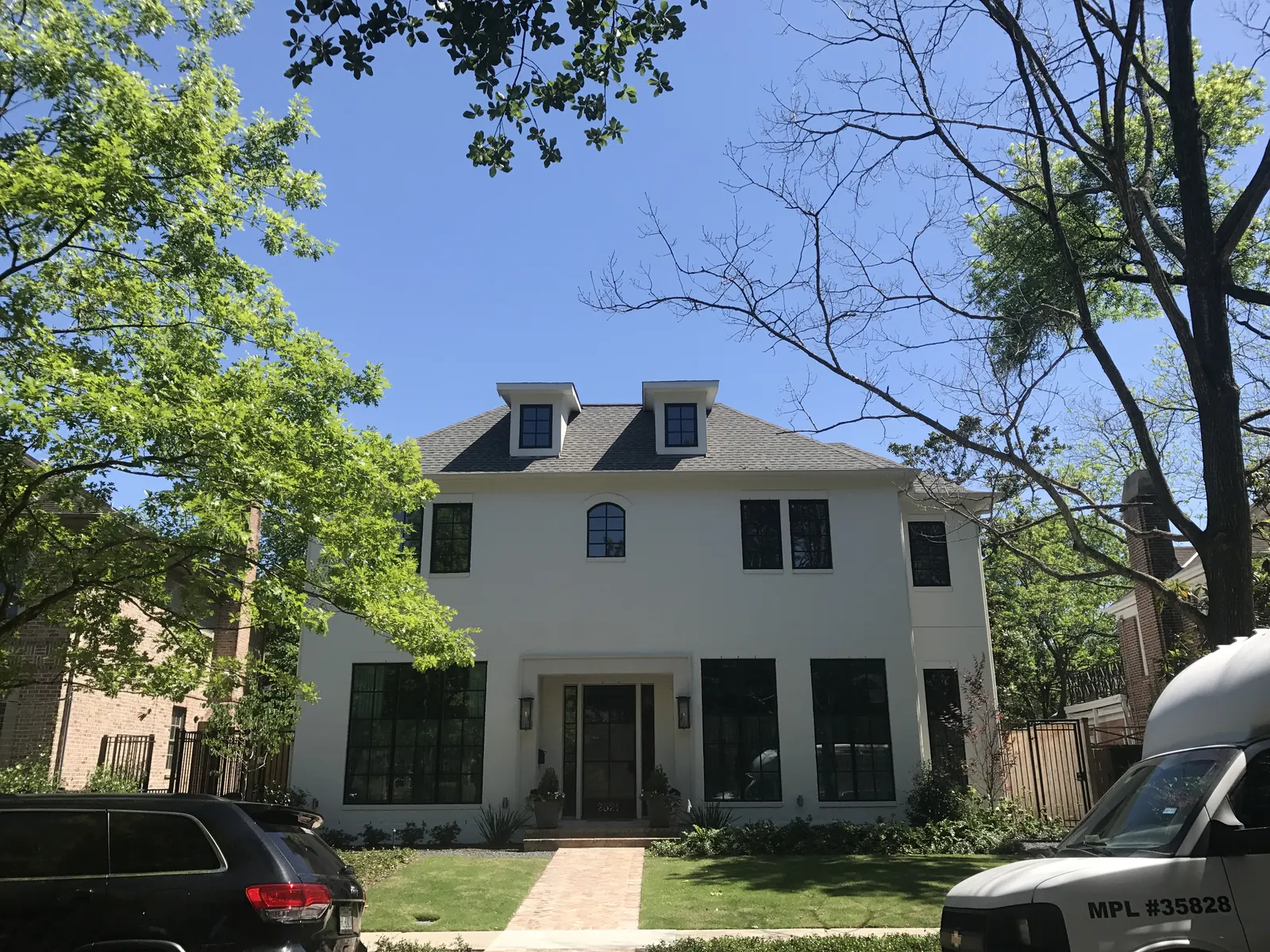 White two-story colonial home with black shutters after an exterior repaint