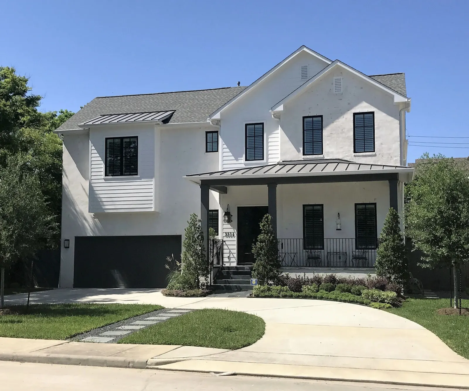 White two-story home with black windows after an exterior repaint by EC Painting