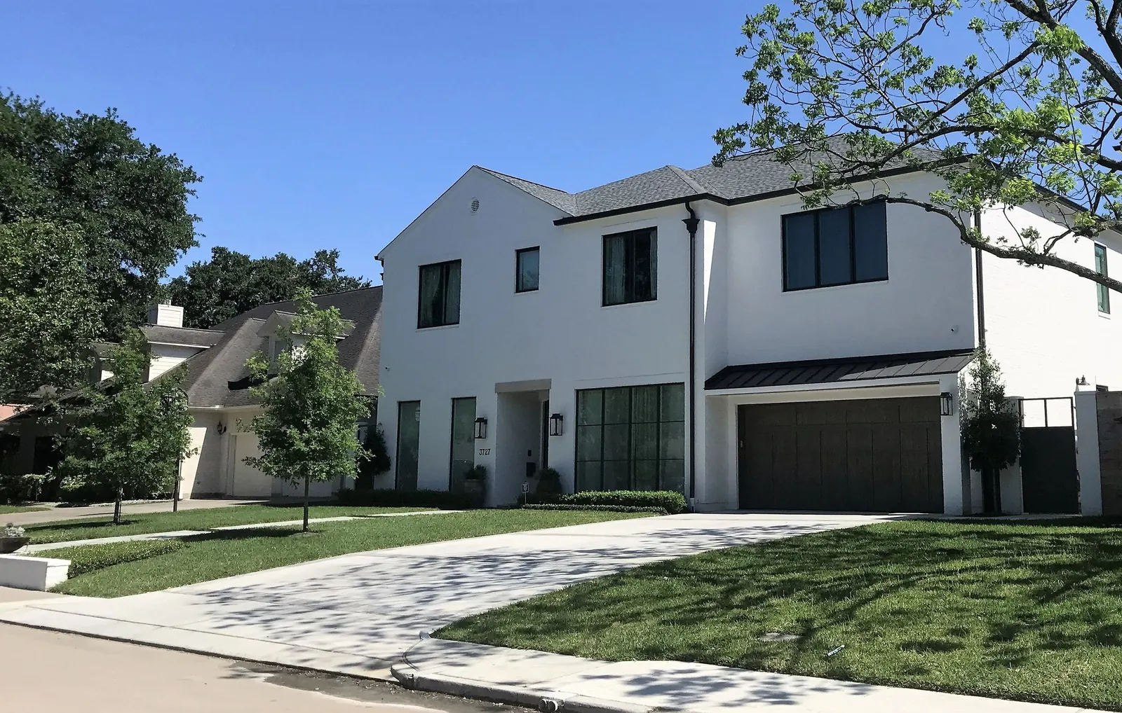 Freshly painted white two-story home with dark garage door