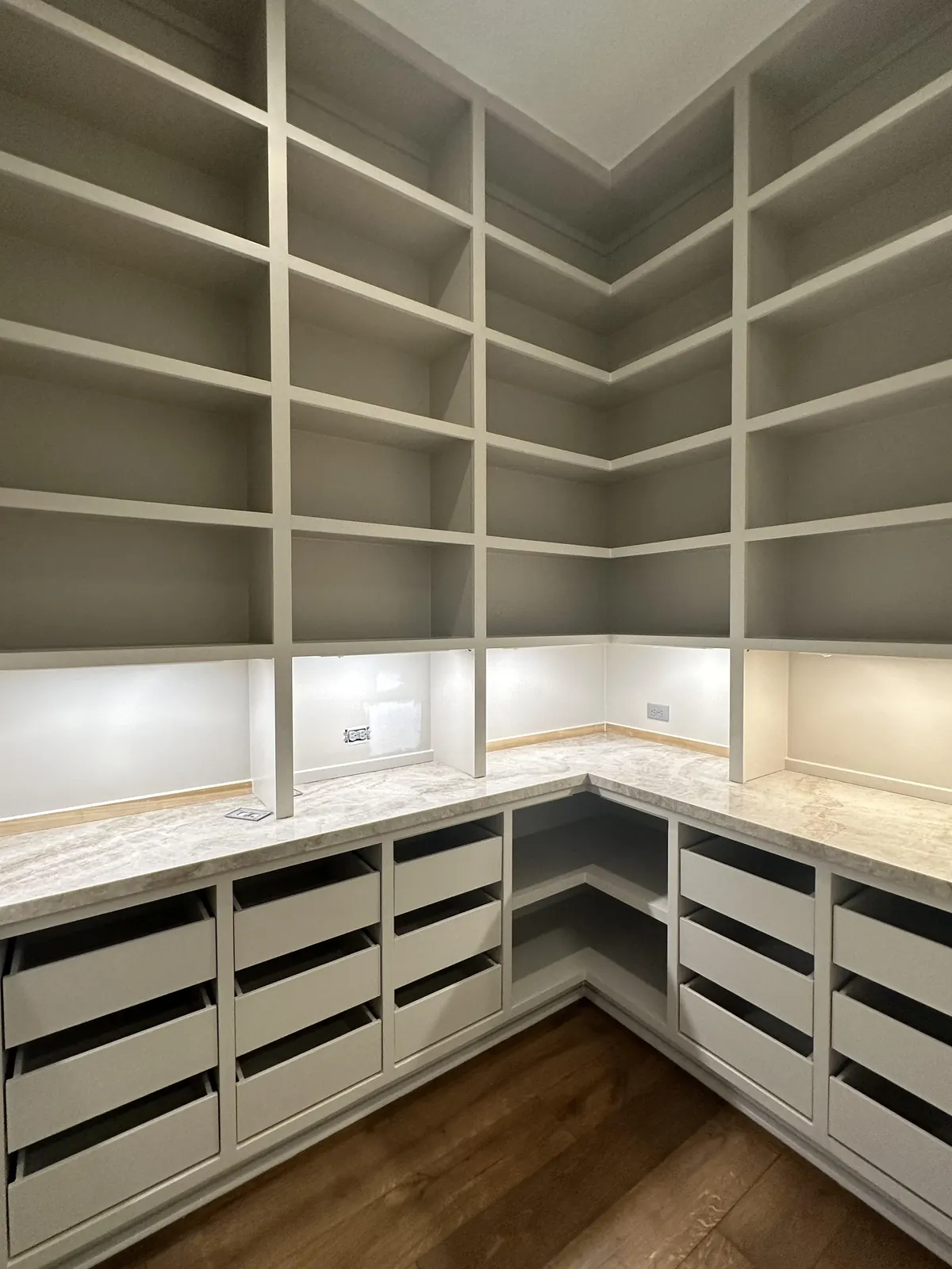 Walk-in pantry with painted built-in shelving and drawers